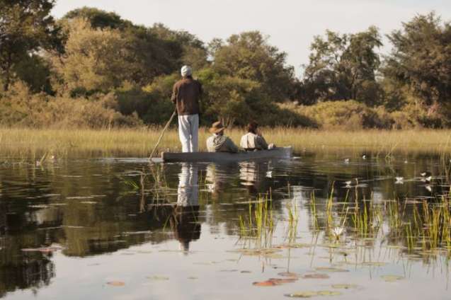 Traditional mokoro canoe gliding through Okavango Delta channels